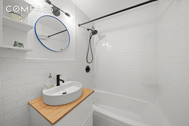 full bath with decorative backsplash, vanity, bathtub / shower combination, and tile walls