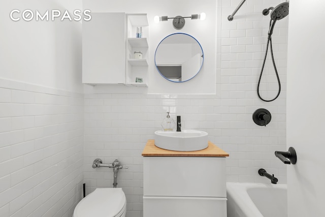 full bath featuring vanity, tub / shower combination, toilet, and tile walls