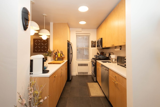 kitchen with light countertops, radiator heating unit, dark tile patterned floors, and stainless steel appliances