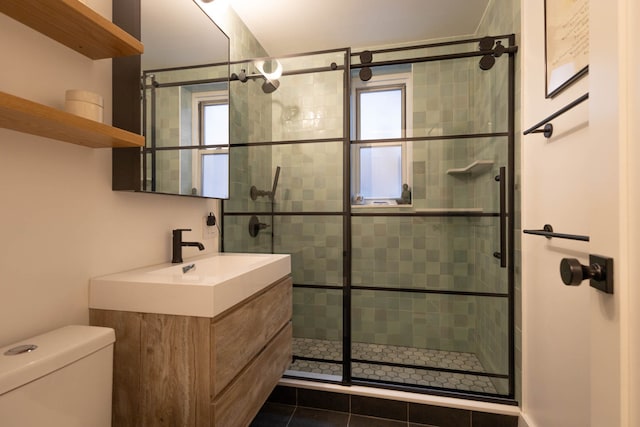 full bath featuring toilet, a stall shower, and vanity