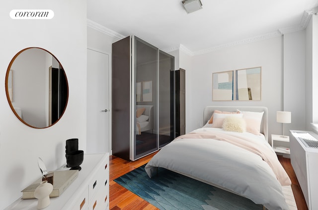 bedroom with light wood-type flooring and ornamental molding