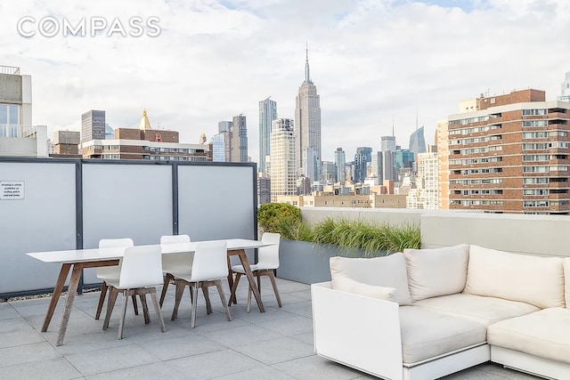 balcony with a view of skyline, outdoor lounge area, and outdoor dining space