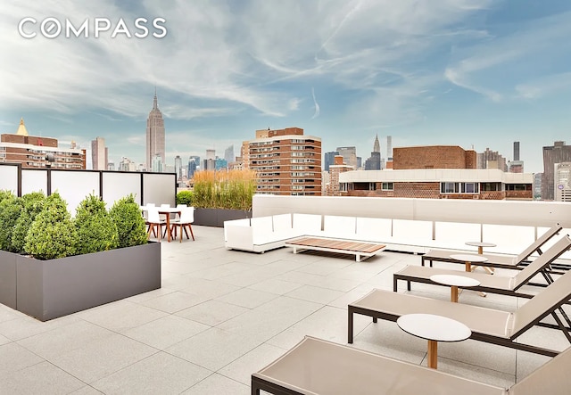 view of patio with a view of skyline and a balcony