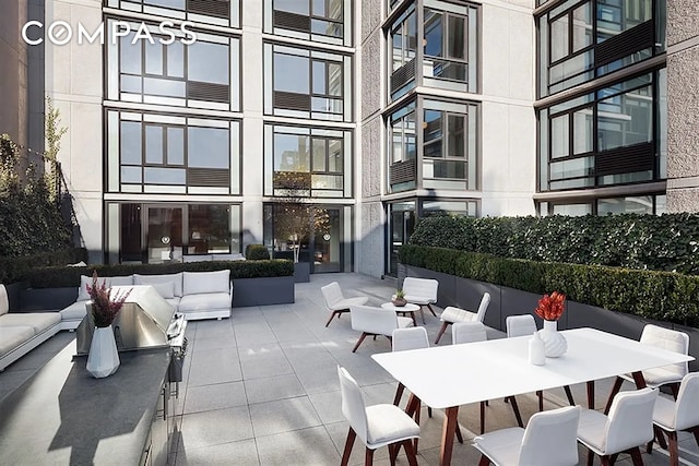 view of community with outdoor lounge area, a patio area, and outdoor dining space