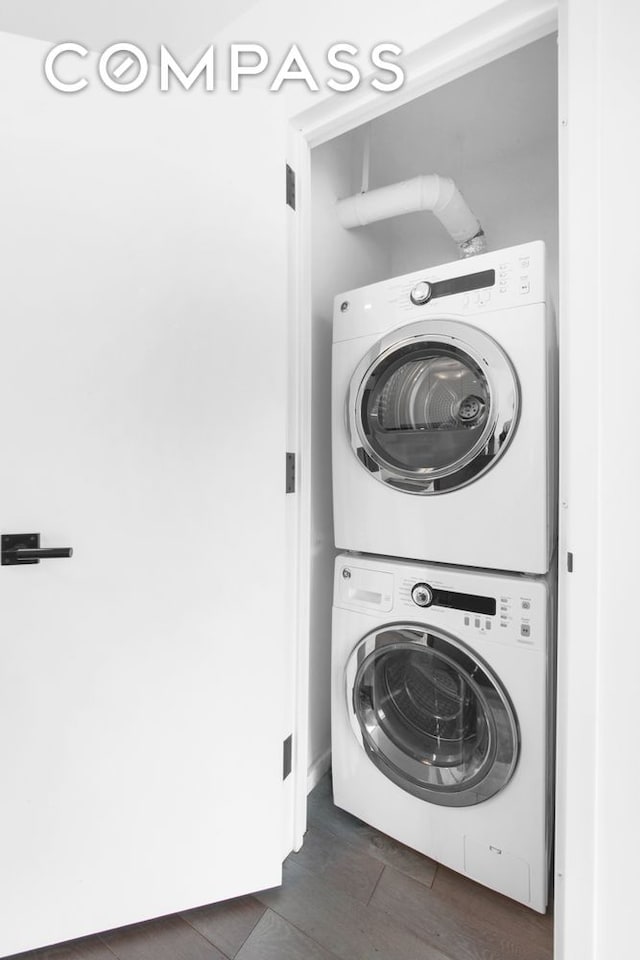 laundry room with stacked washer / dryer and dark wood-style floors