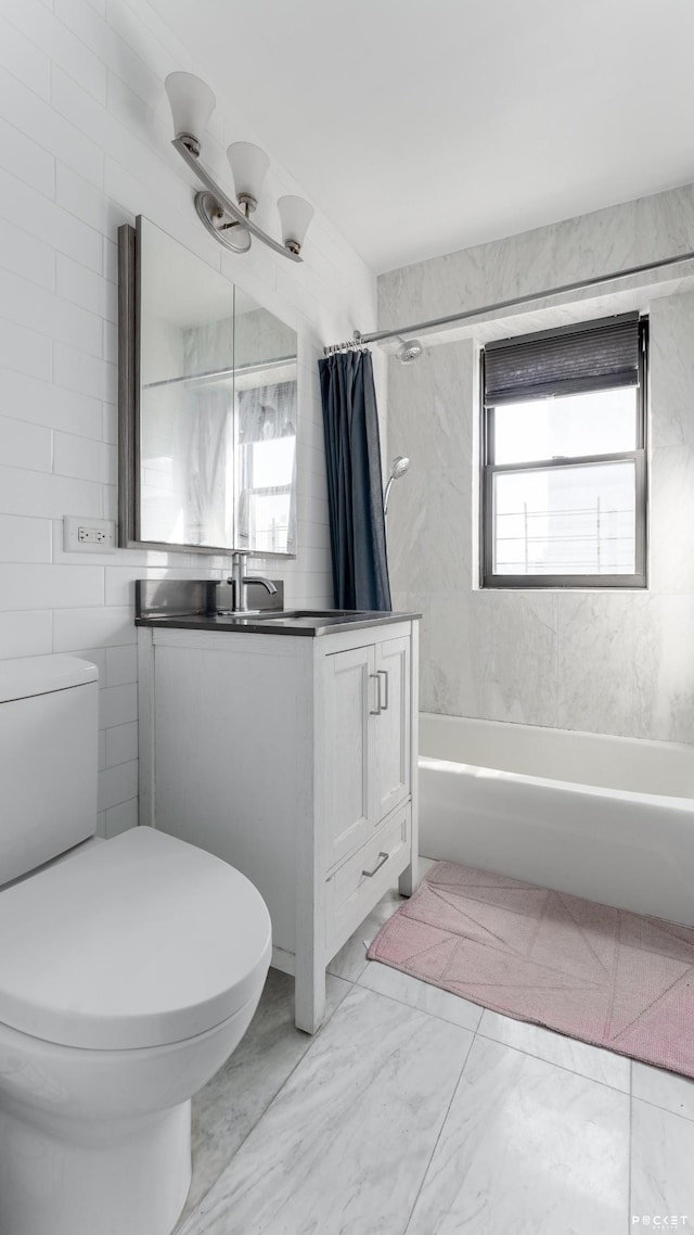 full bathroom featuring toilet, marble look tile flooring, shower / bathtub combination with curtain, vanity, and tile walls