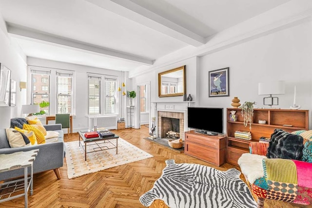 living room featuring beam ceiling and a brick fireplace