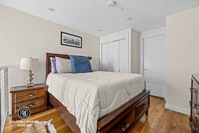 bedroom with a closet, baseboards, and wood finished floors