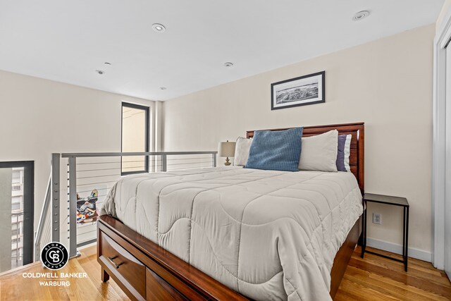 bedroom with recessed lighting, light wood finished floors, and baseboards