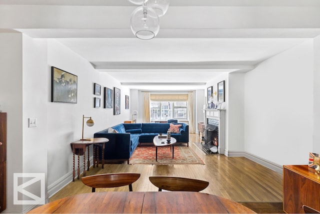 414 E 52nd St Unit 2A, New York City, NY 10022 - living room featuring wood finished floors and a lit fireplace