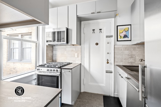 kitchen with white cabinetry, a wealth of natural light, and stainless steel appliances