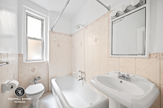 full bath featuring toilet, tile walls, a healthy amount of sunlight, and a sink