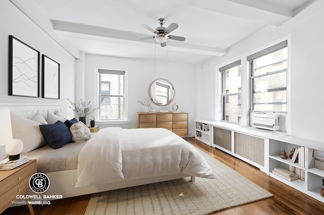 bedroom featuring wood finished floors, radiator heating unit, beam ceiling, and cooling unit