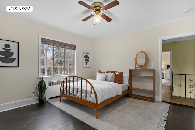bedroom featuring radiator heating unit, baseboards, wood finished floors, and visible vents