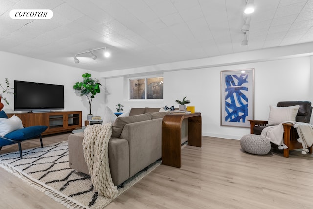 living area featuring track lighting, light wood-style flooring, baseboards, and visible vents