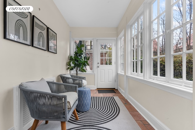 sunroom / solarium featuring baseboards and stone tile floors