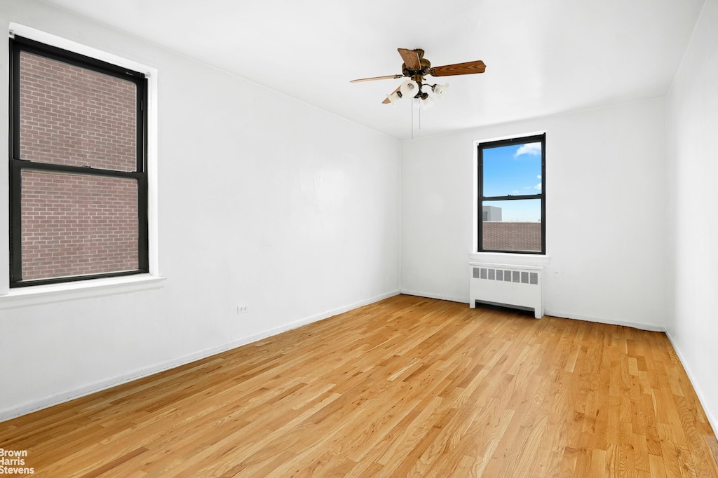 740 E 232nd St Unit 6H, New York City, NY 10466 - unfurnished room with radiator, light wood-style flooring, a chandelier, and baseboards