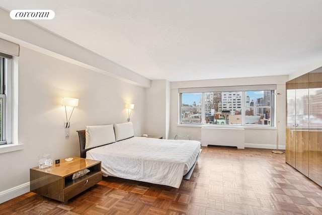 bedroom with baseboards and radiator