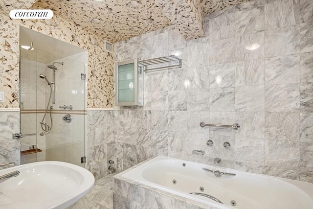 full bath with a shower stall, a sink, a tub with jets, and tile walls
