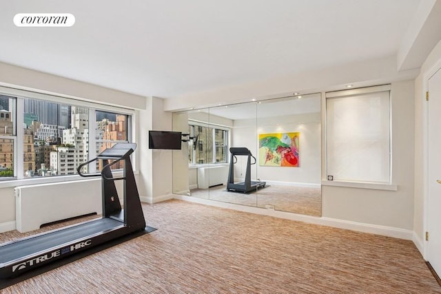 workout room with baseboards and carpet