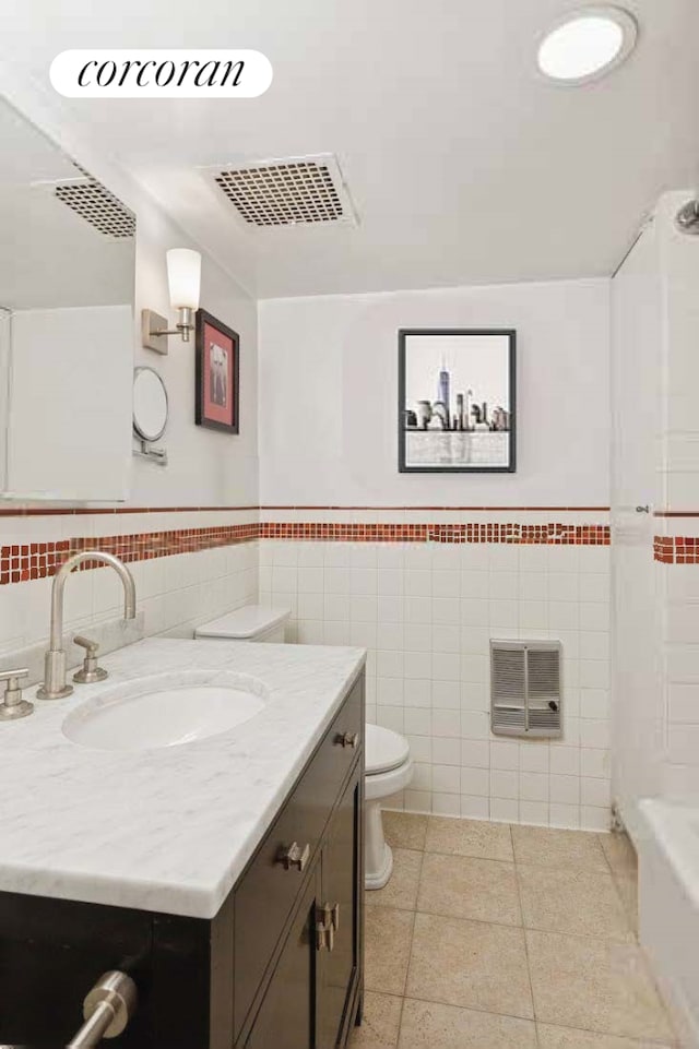 450 W 20th St Garden, Unit Garden, New York City, NY 10011 - bathroom featuring tile walls, vanity, toilet, tile patterned flooring, and a wainscoted wall