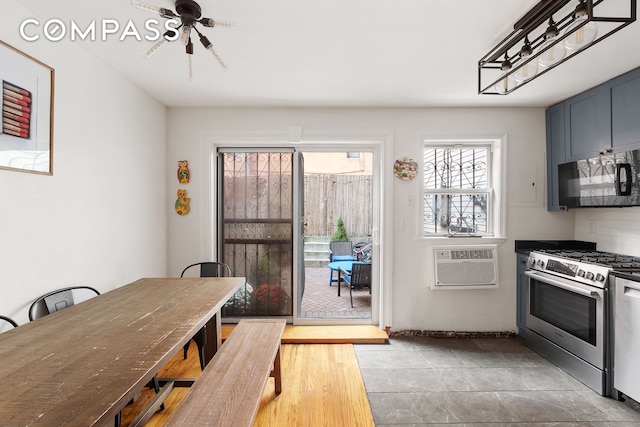 kitchen featuring black microwave, gas stove, a ceiling fan, and a wall mounted AC