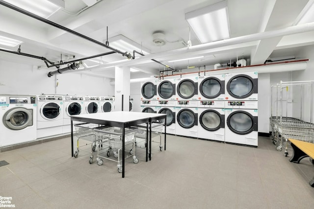 community laundry room with stacked washer / drying machine and washing machine and dryer