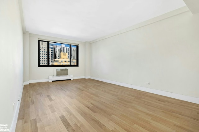 empty room featuring light wood-type flooring and baseboards