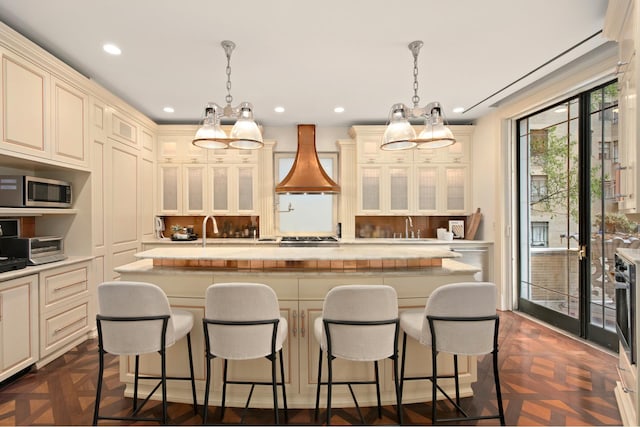 349 W 86th St, New York City, NY 10024 - kitchen with a chandelier, premium range hood, cream cabinets, and recessed lighting