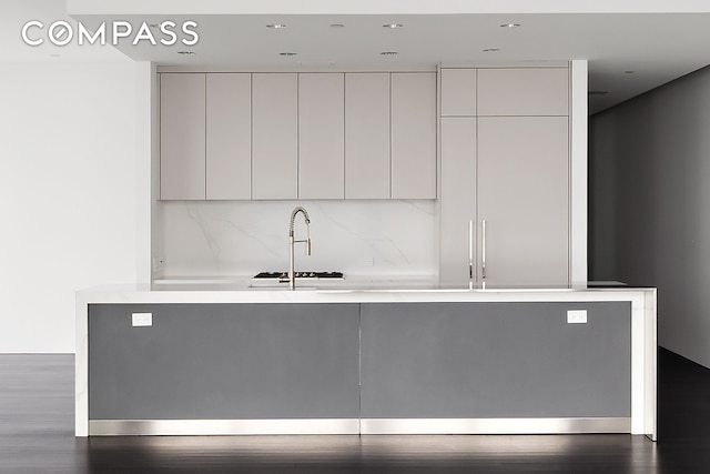 kitchen with modern cabinets, light countertops, dark wood finished floors, recessed lighting, and decorative backsplash
