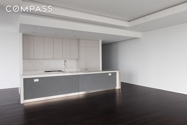 kitchen featuring modern cabinets, dark wood-style floors, light countertops, a sink, and recessed lighting