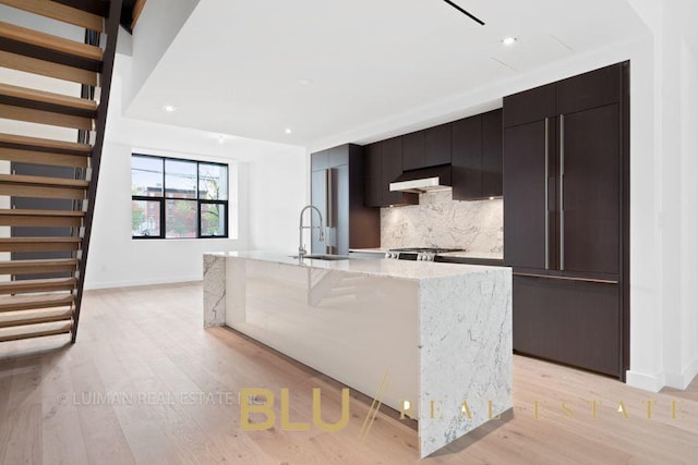 123 King St, New York City, NY 11231 - kitchen with a sink, decorative backsplash, an island with sink, light wood finished floors, and recessed lighting