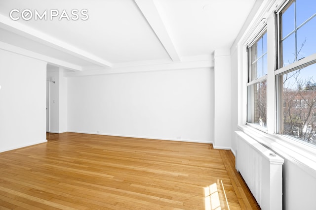 2 Horatio St Unit 8F, New York City, NY 10014 - empty room featuring radiator, beamed ceiling, light wood-type flooring, and baseboards