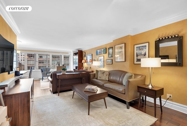 living area featuring baseboards, wood finished floors, visible vents, and crown molding