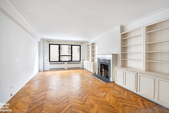 unfurnished living room featuring a premium fireplace, baseboards, and built in features