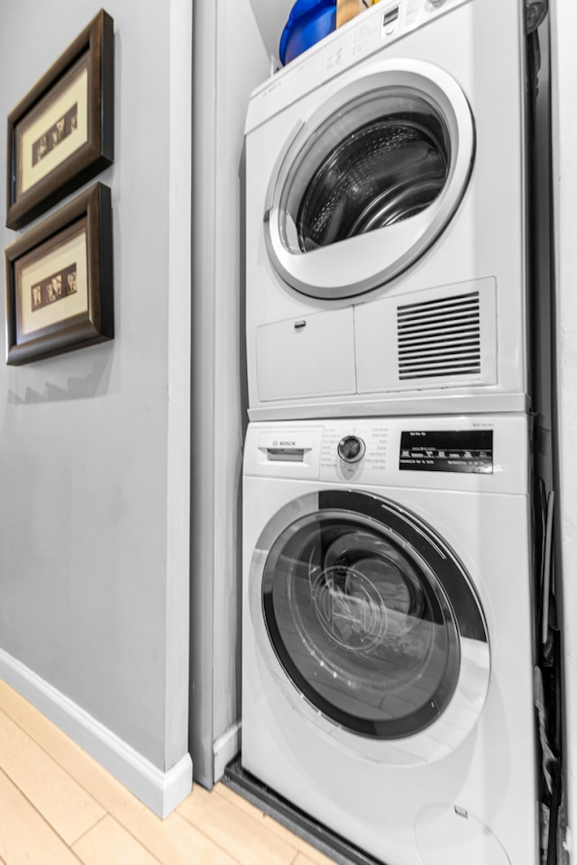 laundry area with stacked washer and dryer, laundry area, and baseboards