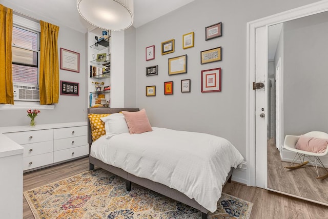 bedroom featuring wood finished floors and cooling unit