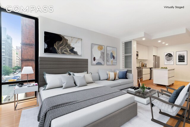 148 E 24th St Unit 4C, New York City, NY 10010 - bedroom featuring recessed lighting, freestanding refrigerator, light wood-type flooring, and a sink
