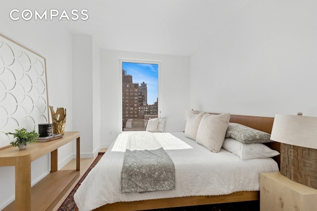 bedroom with a city view and wood finished floors