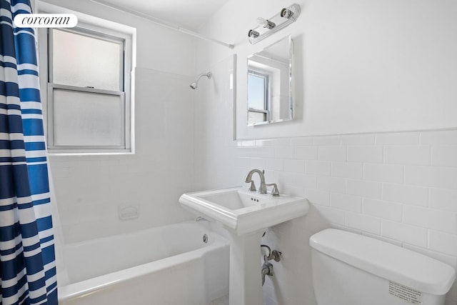 bathroom with tile walls, toilet, and shower / bath combination with curtain