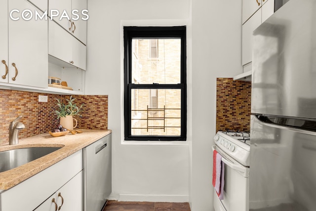 245 E 72nd St Unit 8G, New York City, NY 10021 - kitchen featuring appliances with stainless steel finishes, white cabinets, open shelves, tasteful backsplash, and light stone countertops
