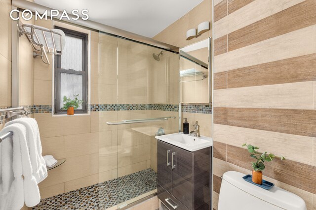 245 E 72nd St Unit 8G, New York City, NY 10021 - full bath featuring tile walls, a shower stall, and vanity