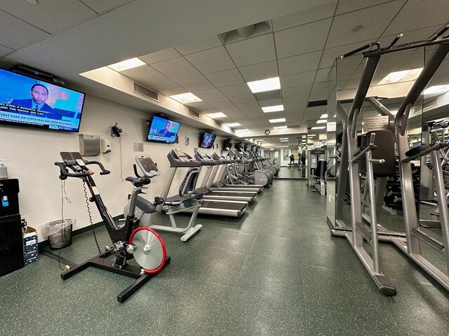exercise room with a paneled ceiling and visible vents