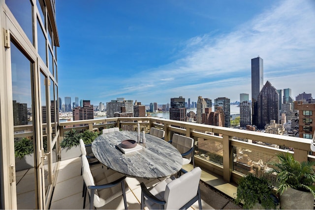 balcony featuring outdoor dining space and a city view