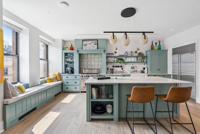 260 W Broadway Unit 9/10B, New York City, NY 10013 - kitchen featuring open shelves, green cabinetry, high quality appliances, and light countertops