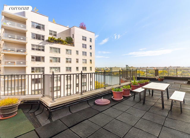 view of patio featuring a water view and a balcony