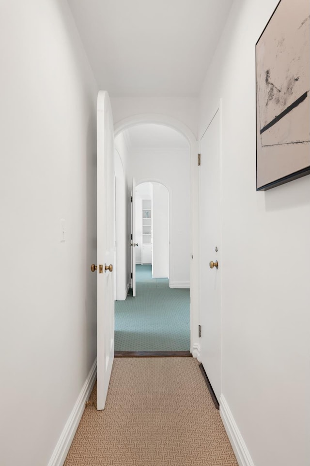 10 E 70th St Unit 12C, New York City, NY 10021 - corridor featuring light carpet, arched walkways, and baseboards