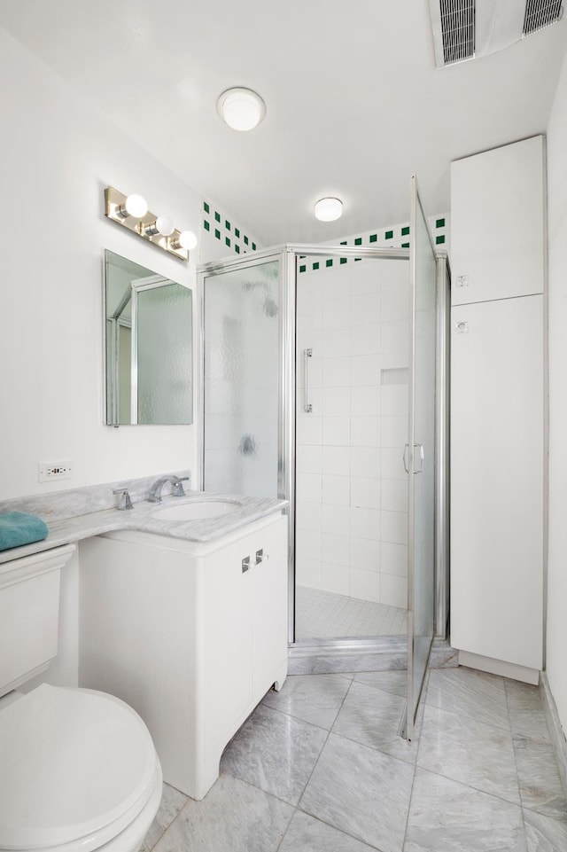 bathroom with toilet, a stall shower, and vanity