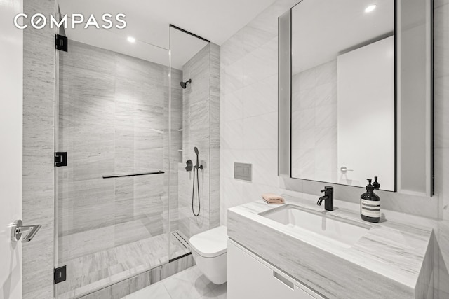 199 Chrystie St Unit 4S, New York City, NY 10002 - full bath with vanity, a shower stall, recessed lighting, marble finish floors, and tile walls