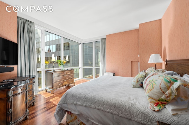 60 E 55th St Unit 40B, New York City, NY 10022 - bedroom with wood finished floors and a textured wall